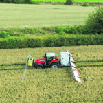 An application of conductive liquid is made ahead of the tractor, while the rear-mounted generator and electrically charged panels do the plant termination at the back end. | Nucrop photo