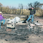 Tyson McKenzie, right, and his father David look over the burned out ruins of their fourth generation farmhouse near Delisle, Sask. | William DeKay photo