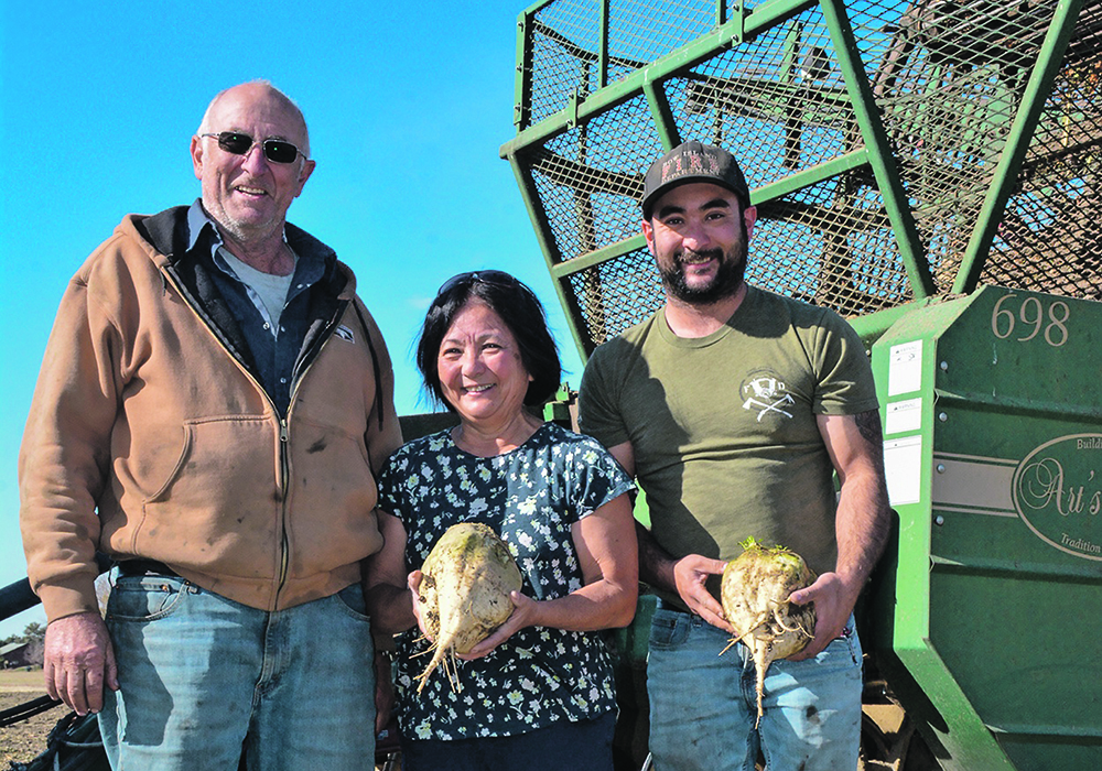 Bernie, left, Sharlene and Gary Lyczewski hold some of the family farm’s sugar beets following this year’s harvest. | Alex McCuaig photo