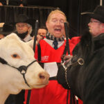 It's black and white who won | Tyler Bullick from Prairie Cove Charolais shows his feelings about winning the female portion of the Beef Supreme Challenge at Agribition with his Bashaw, Alta., neighbour and fellow winner for the bull, Lee Wilson of MIller Wilson Angus. At left is BRCHE Berkly Ann 8507 PLD ET getting to know bull DMM Maximus 18G at right. | Mike Raine photo