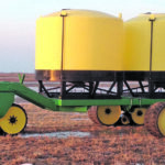 The unique Gramlow triple track caddy carries two 1,600-gallon cone-bottom tanks. The pair of rear tracks exerts 13 p.s.i. on soil while the single front track exerts 10 p.s.i. on the ground. Richard Gramlow says the setup is easier to turn and is easier on the tractor. | Richard Gramlow photo