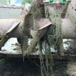 Net wrap tangled on a manure spreader after manure was loaded and spread from a corral where bales with net wrap had been fed shows the potential extent of the danger that the product poses to livestock. | Heather Smith Thomas photo