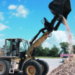 The new roll-out bucket from Werk-Brau gives loaders an extra two-feet of dumping height, thus allowing lighter loaders like this to load trucks with 13-foot, six-inch sides, without using ramps. | Werk-Brau photo
