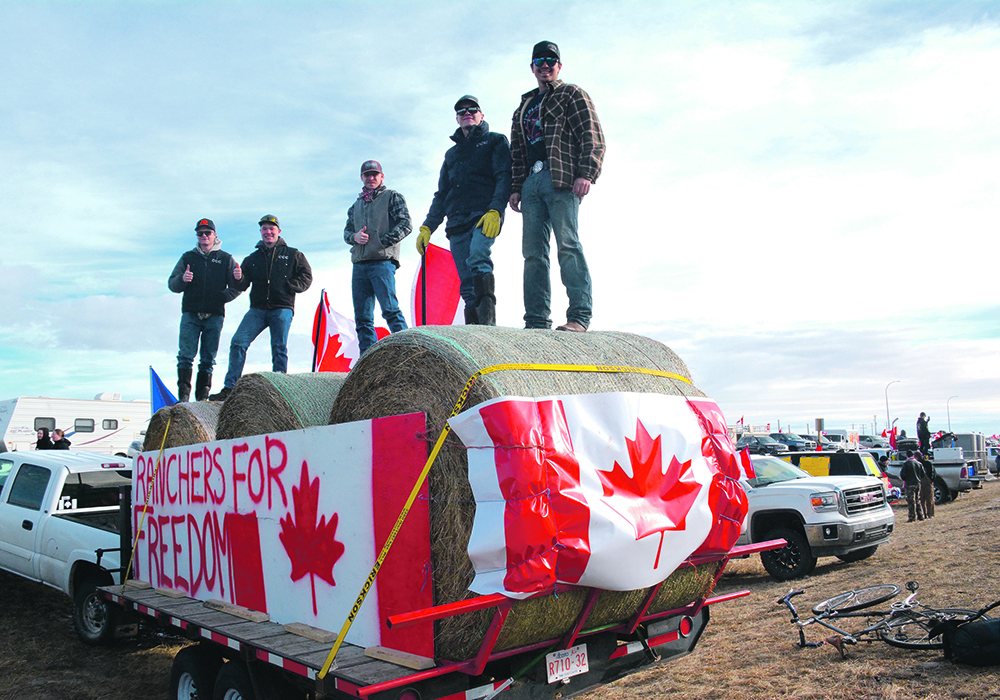 Quin, left, and Liam Connelly, Cole Schweb, Justyn Connelly and Reid Mosby stand on top of hay bales Feb. 6 at the Milk River, Alta., site of the Coutts border protest against pandemic health restrictions. | Alex McCuaig photo