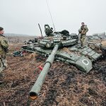 Ukrainian military members inspect a stuck Russian tank on farmland near the village of Nova Basan in Chernihiv region of Ukraine. | Reuters/Serhii Nuzhnenko photo