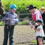 Pat Siemens and her great granddaughter give contestant Ella Malenowski a ribbon. | Jeanine LaSalle photo