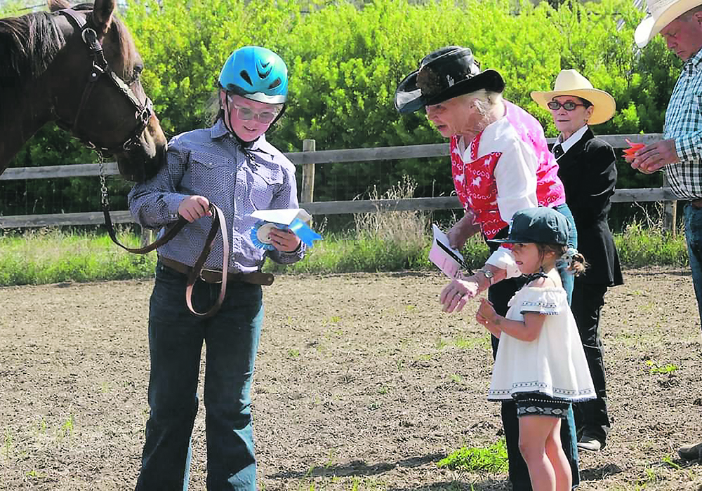 Pat Siemens and her great granddaughter give contestant Ella Malenowski a ribbon. | Jeanine LaSalle photo