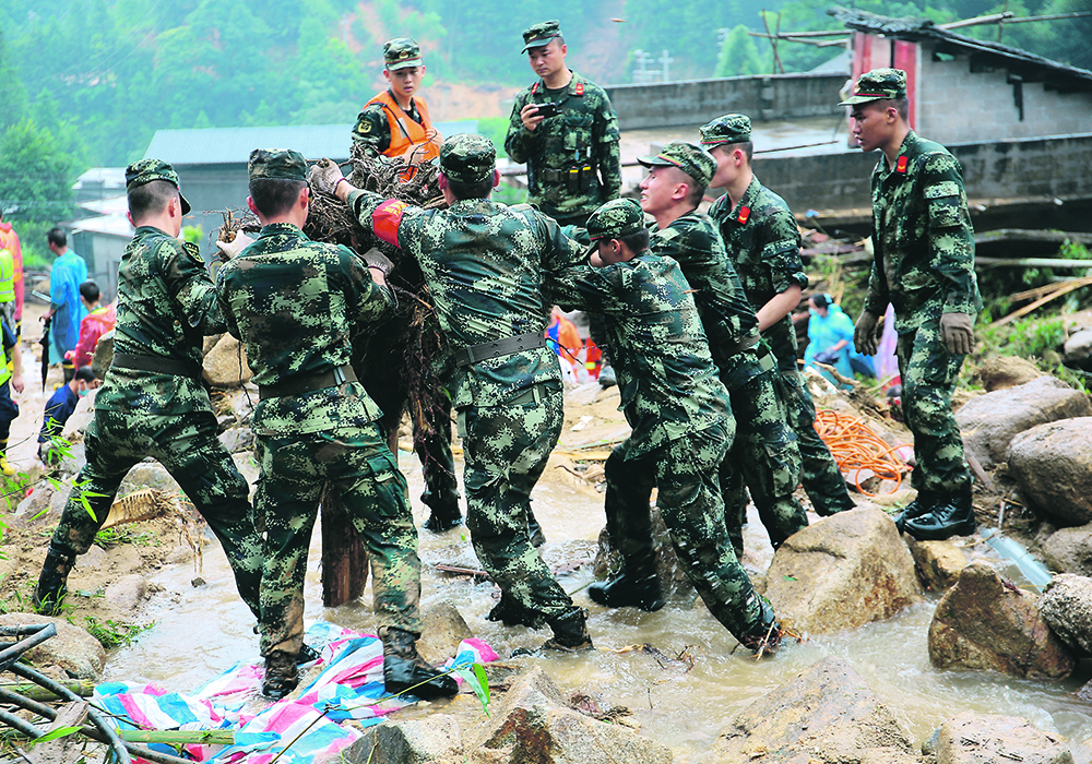 Rescue workers help at the site where a wooden building collapsed following heavy rainfall in Gudu village in the southern region of Guangxi Zhuang, China on Sunday. The highest recorded seasonal rainfall since 1961 has left the region prone to flooding.   |  China News Service via Reuters photo
