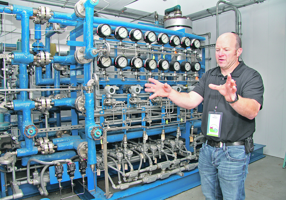 Cory Marquart, who works at the West Central Research and Outreach Center in Morris, MN, explains how the pilot plant at the centre combines nitrogen and hydrogen to make ammonia. | Robert Arnason photo