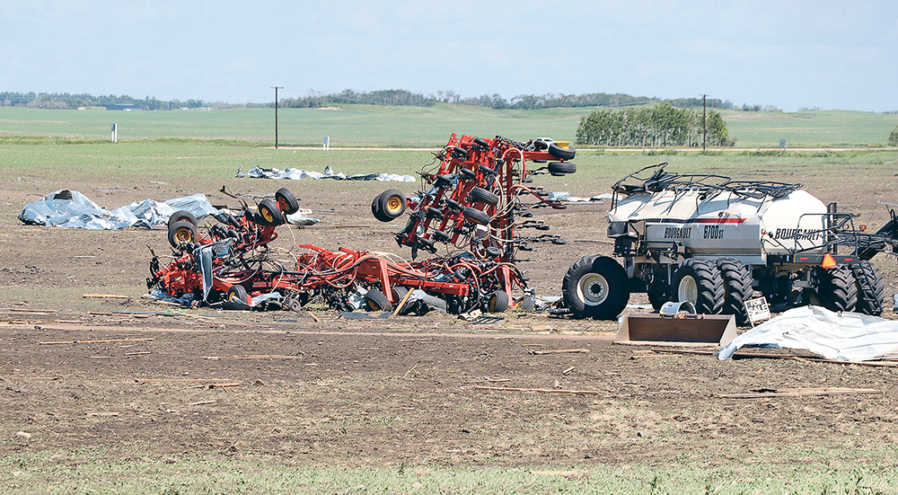 A tornado damaged a farmyard and bin yard west of Foam Lake on June 29, 2022. The image was taken the following day as work crews repaired power lines and cleaned up the yard site. | Robin Booker photo