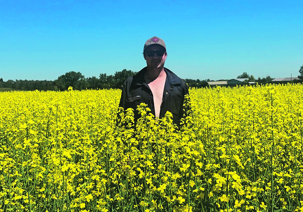 Dale Winter’s canola crop was looking good July 13 when he posed for a photo on his birthday on his farm near Ponoka, Alta. | Photo supplied by Dale Winters