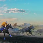 Riders and a wagon race down the track. | Mike Sturk photo