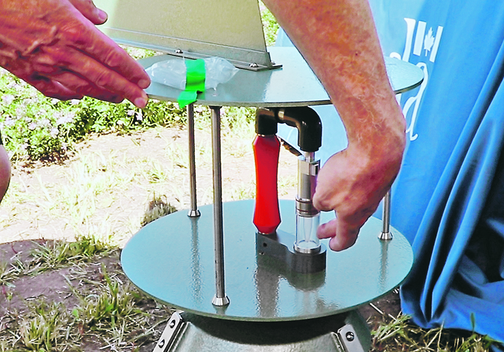 Tim Dumonceaux points at an air sampler that was used in the Ag Canada booth at Ag In Motion. Samples were collected so that event attendees could test them for sclerotinia.  |  Robin Booker photo