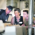 Mike Gallais of Avena Foods in Rowatt, Sask., explains to food processing buyers Heidi Scheiblehner of Bob’s Red Mill in Oregon and Kelly Galbraith of Stauber from Los Angeles how a gravity table sorts oats in the company’s existing oat facility. | Mike Raine photo