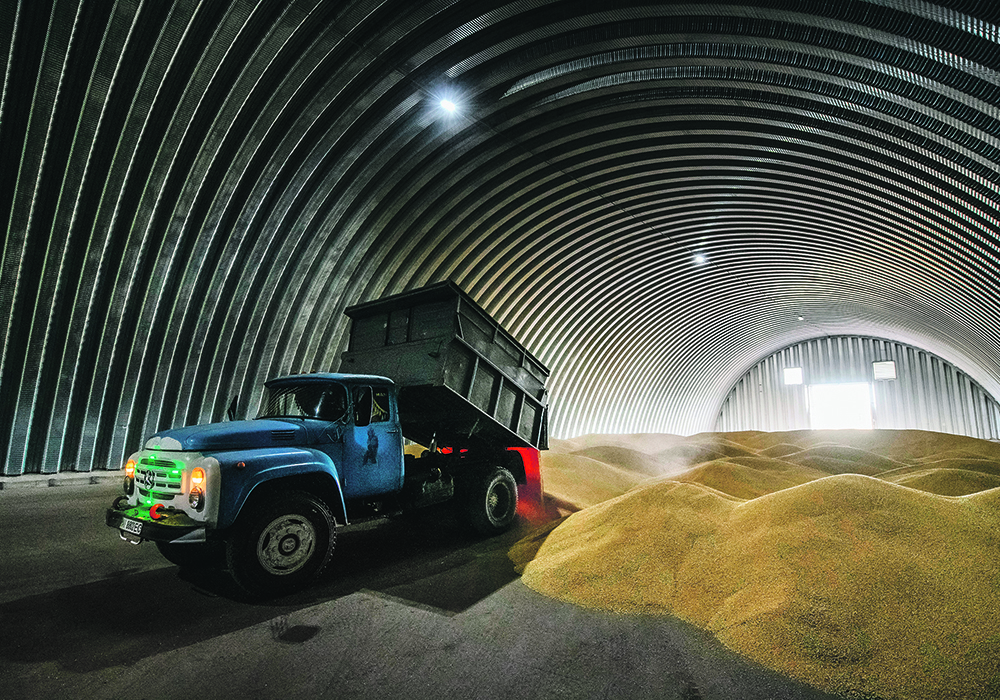 A farmer unloads wheat inside a shed at the village of Zghurivka, near Kyiv, Ukraine. Crops have been good this year, however getting them to market may be another matter.  |  Reuters/Viacheslav Musiienko photo