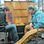 Barry Lehmann of Rosthern, Sask., plays chess with his son, Gavin, in the barn at Farmfair International. | Doug Ferguson photo