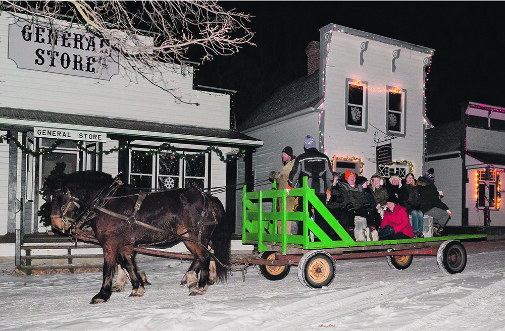Cornie Friesen of Austin, Man., drives his team of Clydesdales through the Pioneer village Dec. 10. With two hay wagons and two teams of horses, visitors can take a ride or just walk the decorated trail. | Sandy Black photo