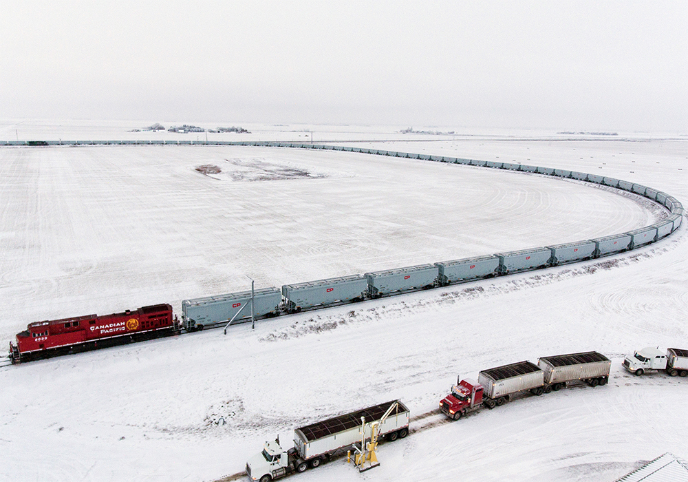 The HEP train is an 8,500 foot (2.6 kilometre) monster that pulls 147 of the new, bigger grain cars and keeps its locomotives attached both when loading at country elevators and when dumping at port. | Screencap via cpr.ca