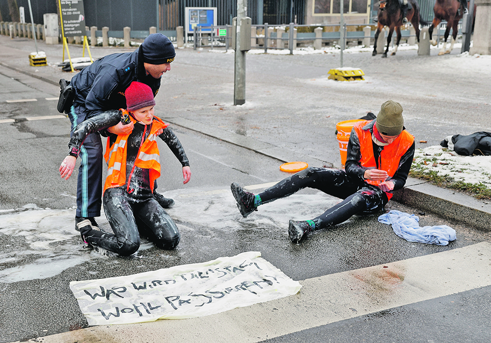 Climate activists glue themselves to a street in Germany late last month as governments and corporations face mounting pressure to deal with climate change.  |  Reuters/ Michaela Rehle photo