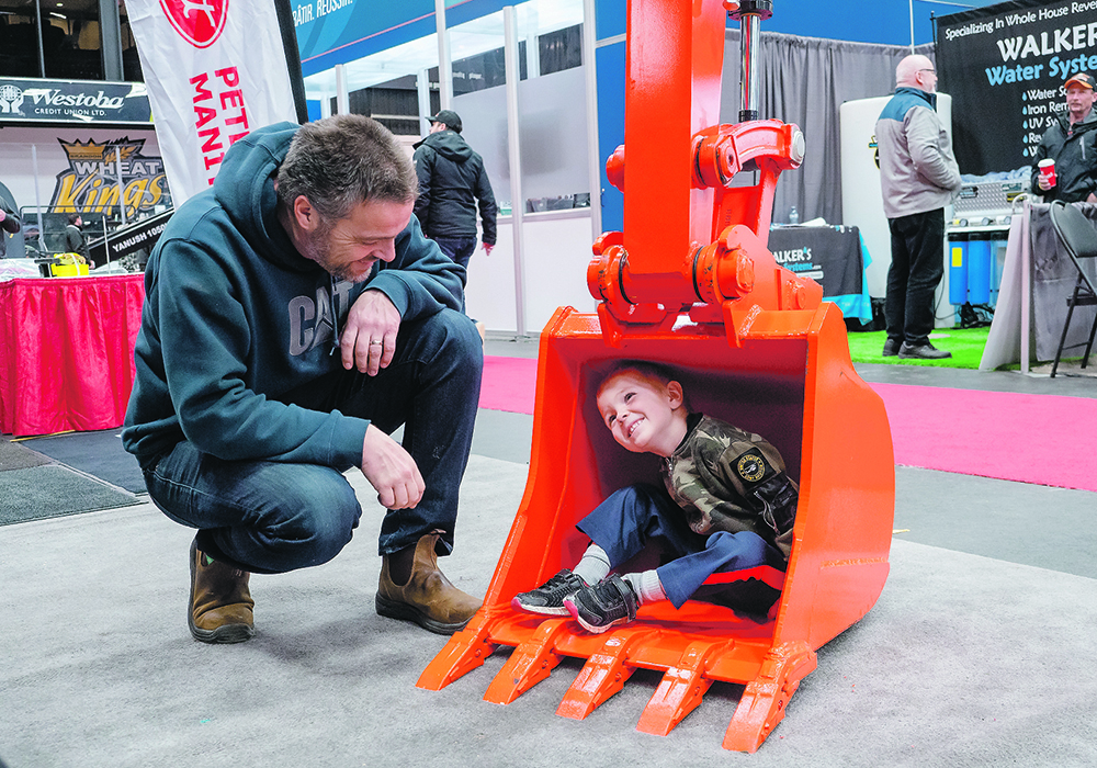 Four-year-old Kyle Krapp and his father, Chris Krapp, check out the bucket of a Kubota back hoe. | Sandy Black photo