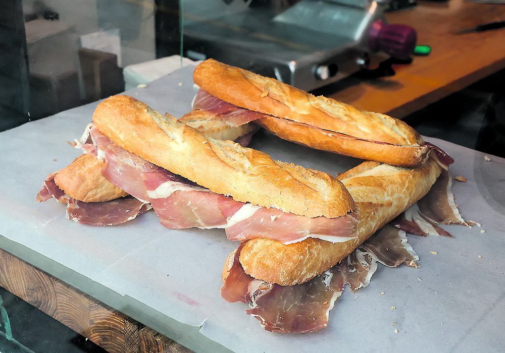 Breads with ham were displayed in the showcase of a Ronda, Spain deli as the Spanish government announced measures to battle food inflation in December.  |  Reuters/Jon Nazca photo