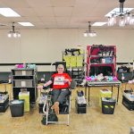 Les Trautman of Camrose, left, and Margaret Shinness of Wetaskiwin, Alta., right, join their sister, Virginia Liebl of Camrose, to help celebrate her 100th donation Feb. 20 at the travelling Canadian Blood Services donation centre in Camrose on Family Day. | Mary MacArthur photo