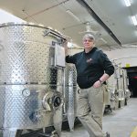 Will Munsey stands beside his specially designed mead vessels in the old fire station in New Sarepta, Alta. | Mary MacArthur photo