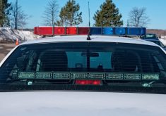 Close-up of the rear of a police car showing lights mounted in the rear window, and red and blue lights on the cruiser's roof.