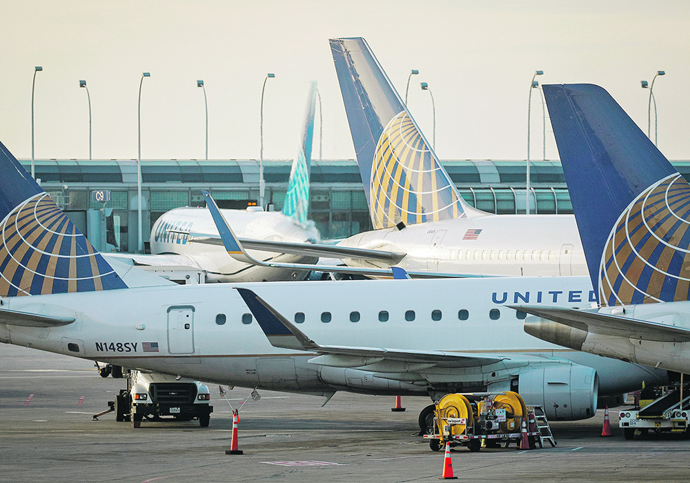 Passenger jets parked at the terminal at a large airport.
