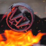 The Agribition logo branding iron positioned over flames.