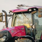 Close-up of a large Case IH tractor with Augmenta sensors mounted on the cab's roof.