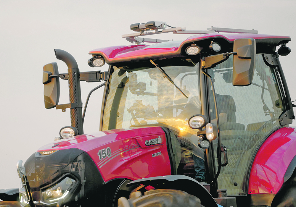 Close-up of a large Case IH tractor with Augmenta sensors mounted on the cab's roof.