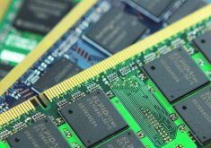 Several circuit boards with chips on them are stacked upon one another.