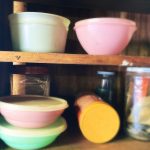 A stock photo of some vintage plastic food storage containers on a shelf.