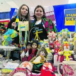 Two Ukrainian women, Olga Boiko and Liudmyla Todorova, stand behind their table full of baked goods, homemade dolls and beaded necklaces they're selling at the Royal Manitoba Winter Fair in Brandon to support the Ukraininan war effort.