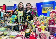 Two Ukrainian women, Olga Boiko and Liudmyla Todorova, stand behind their table full of baked goods, homemade dolls and beaded necklaces they're selling at the Royal Manitoba Winter Fair in Brandon to support the Ukraininan war effort.