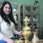 Ala Hakim stands beside an Iranian samovar, which she brought with her to her new home in Forestburg, Alta. The cabinet behind her is full of dishes and memorabilia from Iran.