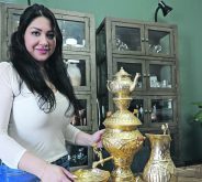 Ala Hakim stands beside an Iranian samovar, which she brought with her to her new home in Forestburg, Alta. The cabinet behind her is full of dishes and memorabilia from Iran.