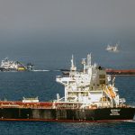 Two grain ships are pictured in the Black Sea. In the background, two other vessels - possibly fishing trawlers - are also visible.