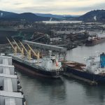 Aerial photo of the Port of Vancouver, with a bulk grain ship at dock waiting to be loaded.