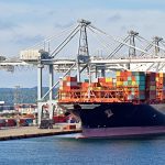 A container ship sits loaded at the dock.