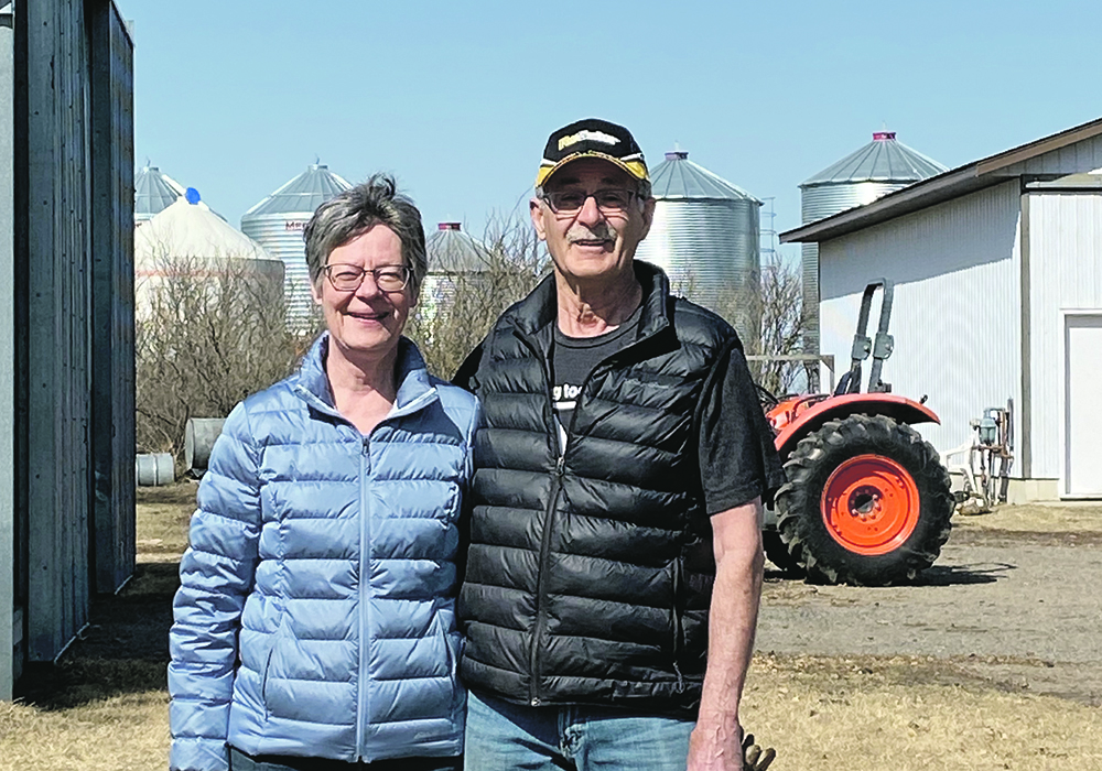 Gaylord and Lois Mierau pose with their arms around one another on their farm near Saskatoon.