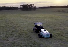 A side-by-side pulls a wheeled device the size of a small trailer over a field to measure carbon sequestration amounts.