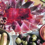 A charcuterie featuring many different colourful types of meats.