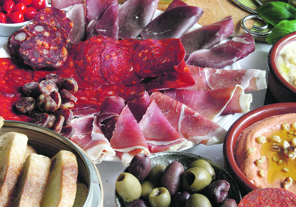A charcuterie featuring many different colourful types of meats.