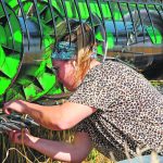 A woman works on the sections of a combine header.
