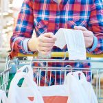 A shopper looks over the bill in a grocery store.
