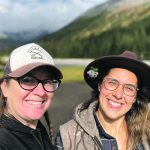 A portrait of two women, author Anna Hunter and photographer Christel Lanthier, with a river, forest and mountains in the background.