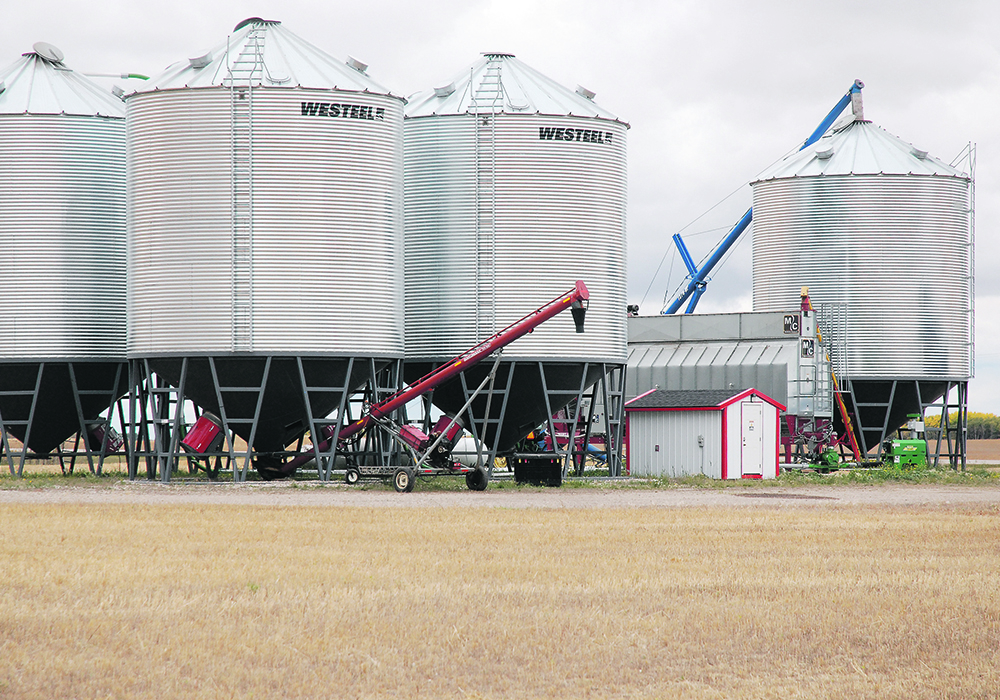 A grain dryer sits amid a bin yard.