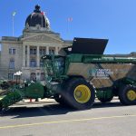 A John Deere X9 combine is parked in front of the Saskatchewan Legislature in Regina.